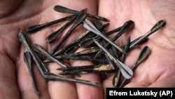 Український сапер показує елементи ураження, якими бувають начинені російські снаряди (фото ілюстративне)