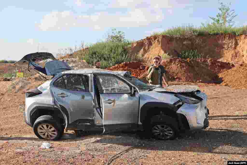 Men inspect a damaged car in Tel Aviv.&nbsp; The scale of the damage from the Iranian strikes remains unclear. One Palestinian man is known to have been killed by a falling section of rocket in the West Bank city of Jericho.&nbsp;