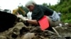 Forensic experts examine a mass grave in Kamenica, Bosnia-Herzegovina, in 2002, near the site of the 1995 Srebrenica massacre.