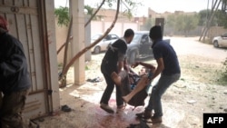 A rebel is carried away after being wounded by a mortar shell that killed two rebels after it was fired by pro-government forces in Al-Ghiran near Misurata airport on May 1.