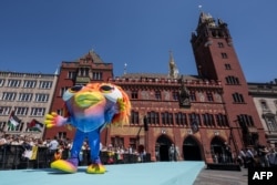 Mascota Eurovision Song Contest 2025, „Lumo”, se plimbă pe covorul turcoaz de lângă Primăria orașului Basel în timpul ceremoniei de deschidere, pe 11 mai 2025.