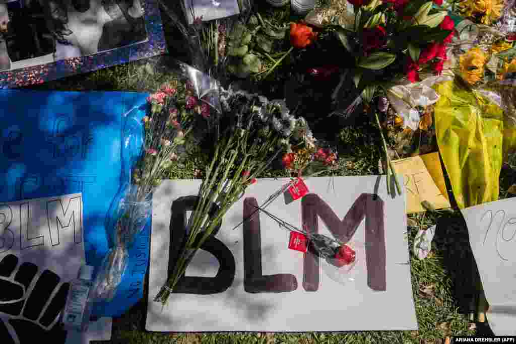 A "BLM" Black Lives Matter sign and flowers can be seen on the ground at a makeshift memorial at Palmdale City Hall for Robert Fuller, a young black man who was found hanging from a tree, on June 16, 2020, in Palmdale, California.