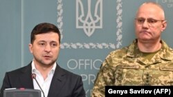 Ukrainian President Volodymyr Zelensky speaks, flanked by Ruslan Khomchak, military commander of the Armed Forces of Ukraine, at a briefing following an outbreak of violence with Russia-backed separatists, in Kyiv on February 18.