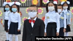 KYRGYZSTAN -- Kyrgyz schoolchildren wearing a protective mask to prevent the spread of the novel coronavirus (covid-19) and keeping a social distance of 1.5 meters stand in lined up at the school before classes in Bishkek, September 1, 2020