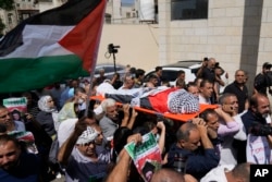 Sute de oameni au participat la funeraliile activistei în Nablus, purtând-o pe umeri prin mulțime, înfășurată în streagul Palestinei și fularul tradițional palestinian keffiyeh.