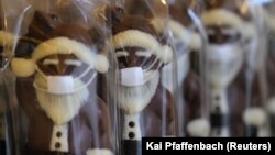 Шоколадные фигурки Санта Клауса в маске, изготовленные германскими кондитерами к Рождеству. Франкфурт, 23 ноября 2020 года.