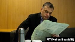 Viktor Orbán, citind un ziar în studiourile Radioului Ungar, 15 februarie 2013.