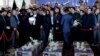 Iranian President Hassan Rohani (left) prays near the coffins of victims who died in a terror attack at the Iranian parliament in Tehran. 