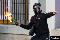 Një protestues duke hedhur koktej molotovi drejt policisë. Tiranë, 18 tetor 2026.