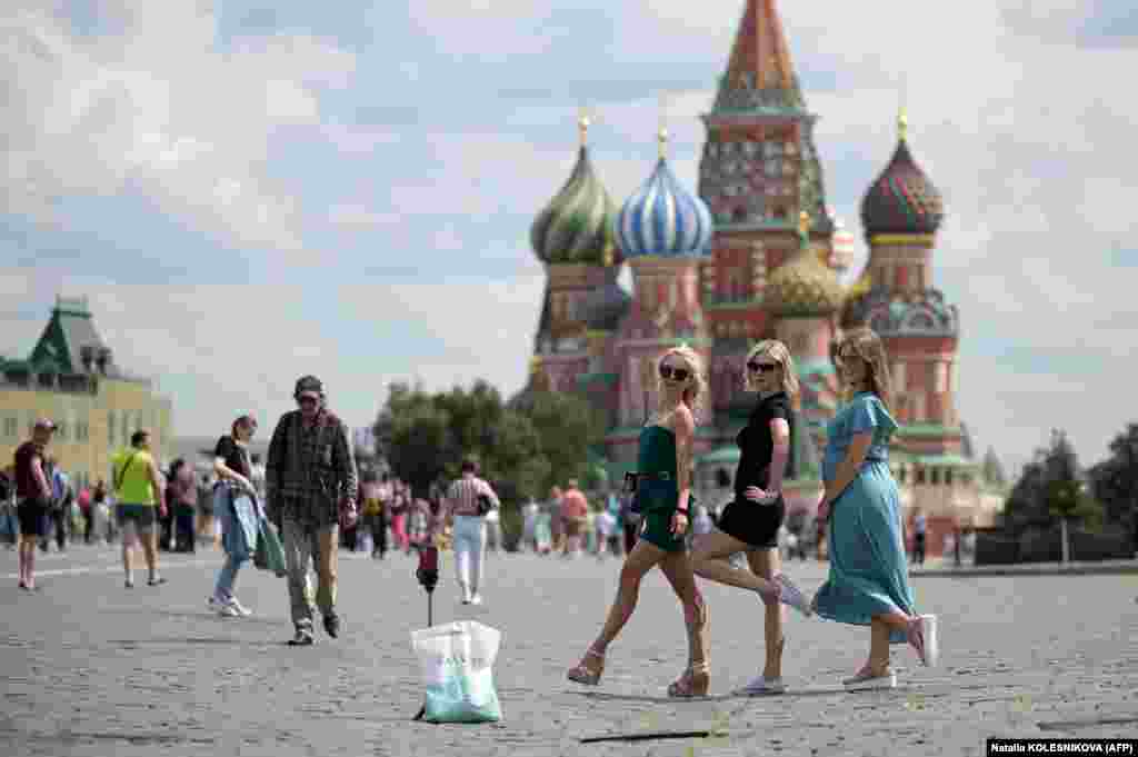 Girls pose for a selfie on Red Square near St. Basil&#39;s Cathedral in Moscow.