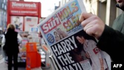 Мужчина держит в руках номер газеты Sun с фотографией британского принца Гарри на обложке. Иллюстративное фото.