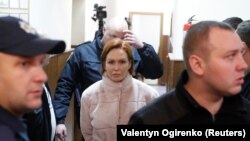 Yulia Kuzmenko is escorted to a court hearing in Kyiv on December 13.