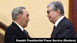 Kazakhstan - Acting President of Kazakhstan Kassym-Jomart Tokayev (R) shakes hands with his predecessor Nursultan Nazarbayev during a joint session of the houses of parliament in Astana, Kazakhstan March 20, 2019. Kazakh Presidential Press Service/Handout