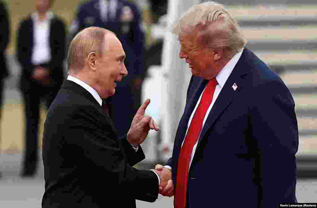 Дональд Трамп і Володимир Путін обмінюються рукостисканням