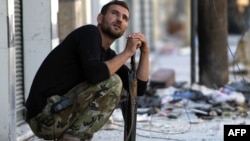 A Syrian rebel fighter watches the sky after hearing a helicopter Aleppo's al-Amiriya neighborhood on September 24. 