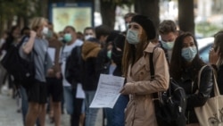 Люди в очереди у пункта сдачи тестов на коронавирус в Праге.