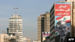 A poster of slain former Lebanese Prime Minister Rafik Hariri hangs from a building still bearing the scars of Lebanon's civil war in Beirut.