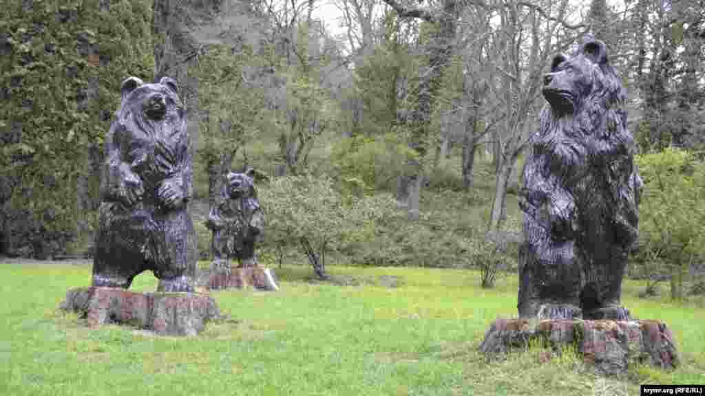 Напротив памятной таблички расположились скульптуры трех медведей из сказки. Они выполнены мастером Кравчуком, который творчески подошел к обработке засохших и погибших секвоядендронов, превратив мертвые стволы в садовые скульптуры