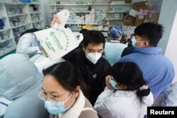 Mai mulți oameni au așteptat la cozi lungi în farmacii pentru a cumpăra teste Covid-19, în orașul Hangzhou, din provincia Zhejiang.