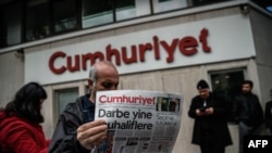 A man reads a copy of the Cumhuriyet daily newspaper in front of the newspaper's headquarters in Istanbul during a police operation on October 31. 