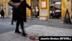 Ploča u centru sarajevske ulice Ferhadija (u sredini, gore) na kojoj piše: "Na ovom su mjestu srpski zločinci 27.5.1993. ubili 26 građana Sarajeva" za koju gradonačelnik Istočnog Sarajeva traži da se ukloni, (12. april 2021.)