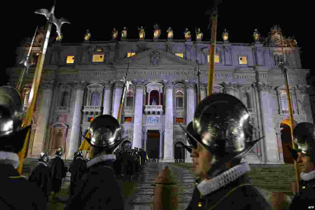 Swiss guards arrive while the balcony where the new pope will appear is seen in the background minutes after white smoke rose from the chimney on the Sistine Chapel.