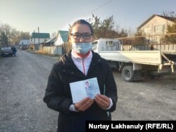 Кайша Акан держит удостоверение беженца, выданное сроком на один год. Алматинская область, 30 октября 2020 года.