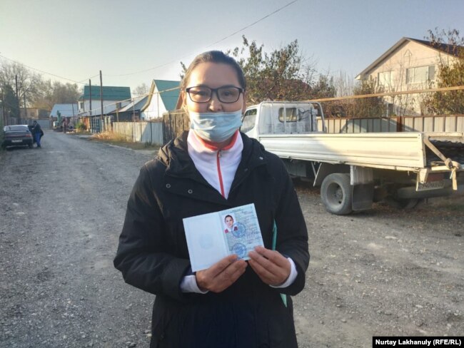 Кайша Акан держит удостоверение беженца, выданное сроком на один год. Алматинская область, 30 октября 2020 года.