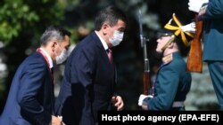 Kyrgyz President Sooronbai Jeenbekov (center) arrives at the Kremlin prior to the military parade to mark the 75th anniversary of victory in World War II on Red Square in Moscow on June 24.