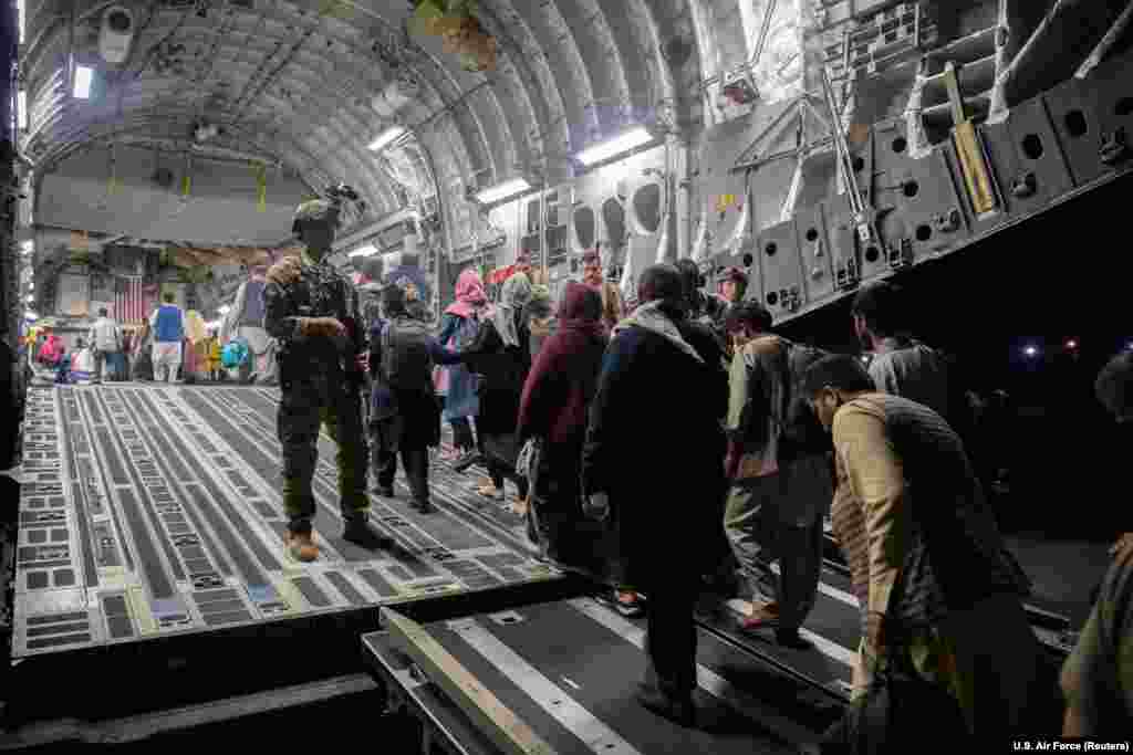 Afghans board a U.S. transport plane during an evacuation on August 22.&nbsp;