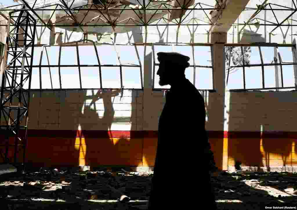 An Afghan man inspects broken glass from his garage at the site of a suicide attack in Kabul on May 31. (Reuters/Omar Sobhani)