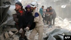 Syria -- Syrian civil defence volunteers evacuate wounded people following a reported airstrike in the rebel-held neighbourhood of Hayy Aqyul in the city of Aleppo, April 22, 2016