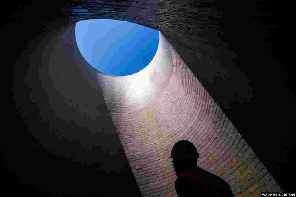 An employee stands inside a cooling tower at the still-to-be-completed third and fourth units at the Mochovce nuclear power plant in western Slovakia. The launching of the two new units has been a cause for concern in neighboring Austria, which has repeatedly criticized what it insists are their poor safety standards. (AFP/Vladimir Simicek)