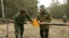 Архівне фото 2006 року, на якому зображено робітників, які встановлюють знак попередження про радіаційну небезпеку поблизу села Бабчин, Білорусь. Фото: Василь Федосенко (Reuters)