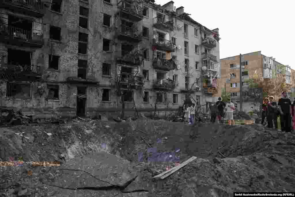 Люди біля вирви після російської атаки