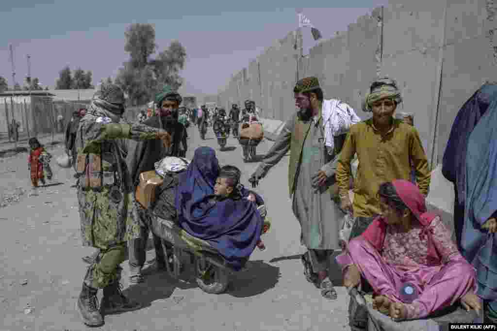 People with their belongings cross into Pakistan from Afghanistan at the Spin Boldak border crossing.&nbsp;