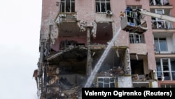 Пожарный работает на месте обрушения жилого дома в результате россйской атаки на Киев, Украина, 27 декабря 2025 года