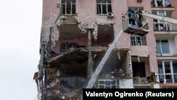 Пожарный работает на месте обрушения жилого дома в результате россйской атаки на Киев, Украина, 27 декабря 2025 года