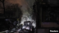 Firefighters work at a site of a Russian missile strike, amid Russia's attack on Ukraine, in Kyiv Ukraine February 12, 2025.REUTERS/Gleb Garanich