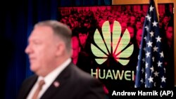 Monitor Mike Pompeo külügyminiszter mögött a Huawei emblémájával a washingtoni külügyminisztériumban tartott sajtótájékoztatón, 2020. július 15-én.