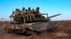 In this photo taken from video distributed by the Russian Defense Ministry Press Service on November 27, Russian soldiers ride a T-90M Proryv tank during combat training in an undisclosed location.