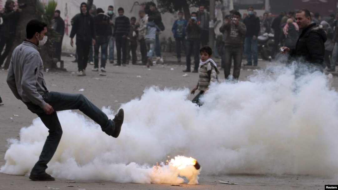 An Egyptian protester kicks a gas canister during clashes with security forces in Cairo.