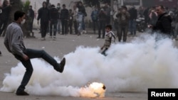 An Egyptian protester kicks a gas canister during clashes with security forces in Cairo.