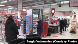 Horsens: supermaket, punctele rosii marchează „distanța socială” la coada la casă. 