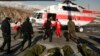 In this photo released by Iran's Red Crescent Society, rescuers work to unload bags containing bodies of mountaineers who died after avalanches in a mountainous area north of the capital, Tehran, on December 26.