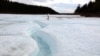 A woman walks on the surface of the glacier, which covers over 1,000 hectares. Thanks to dozens of meters of permafrost underneath, the ice doesn&rsquo;t melt, even during exceptionally hot summers.