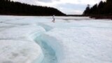 Жена се разхожда по повърхността на глетчера, който покрива площ от над 1000 хектара. Благодарение на десетките метри трайно замръзнала земя отдолу ледът не се топи дори през изключително горещо лято.