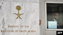 A staffer looks through the door at the entrance to the Saudi Embassy in Washington on October 11.