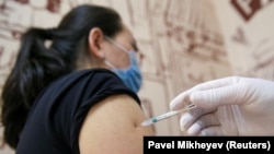 Медицина қызметкері тұрғынға коронавирусқа қарсы вакцина салып жатыр. Алматы, сәуір айы 2021 жыл. 