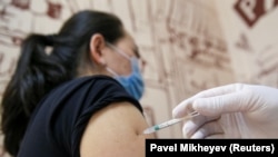 Женщина получает дозу вакцины против заболеваний коронавируса (COVID-19) в центре вакцинации, расположенного в торговом центре в Алматы, 27 апреля 2021.